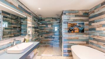 Une salle de bain moderne avec une grande baignoire, une douche à parois de verre et un mur décoré de bois au style rustique.