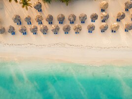 On the beach, white sand, sun loungers, beach umbrellas