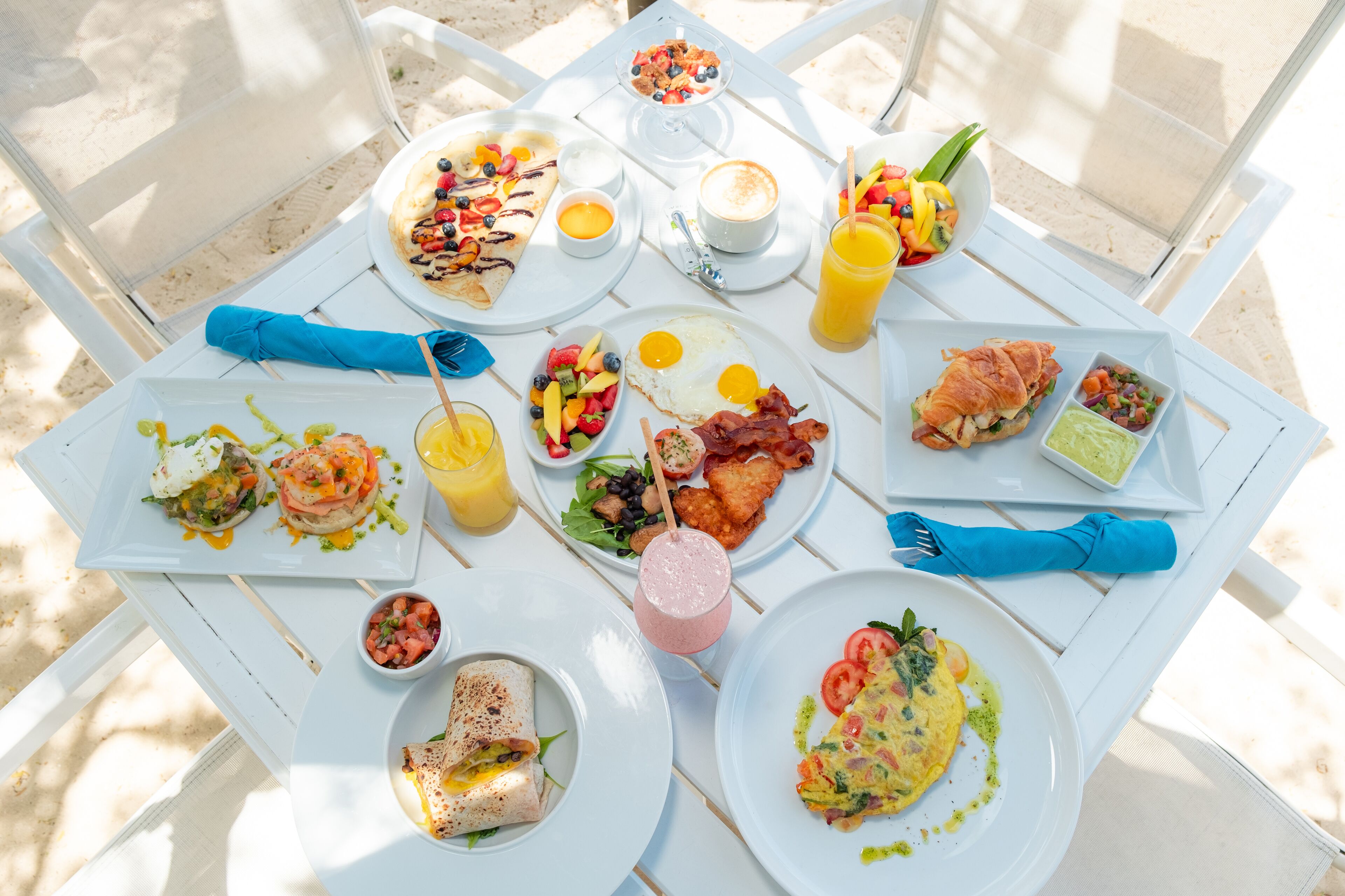 A table set with various breakfast dishes, including eggs, toast, and fruit.