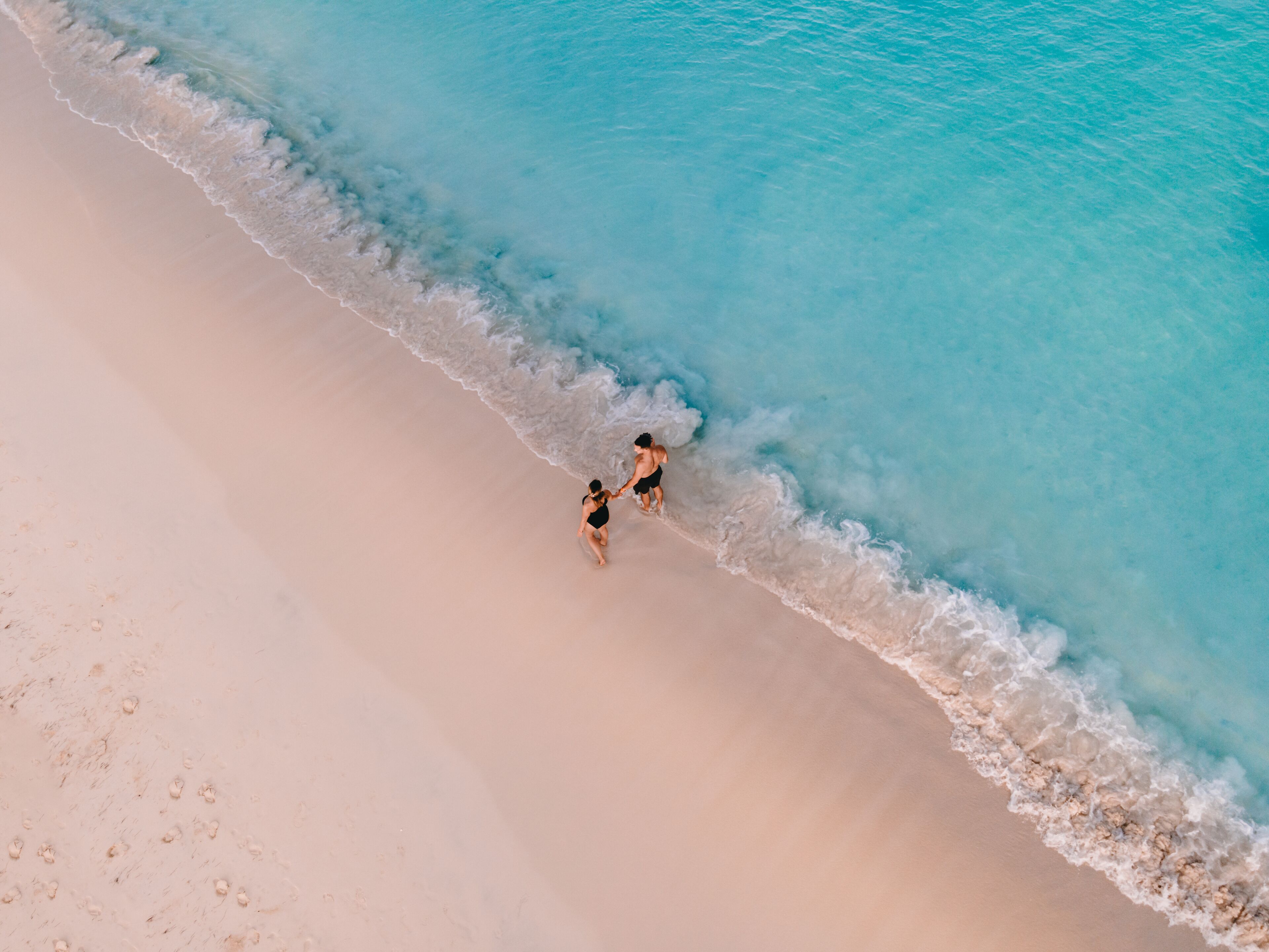 A beach with clear turquoise water and a sandy shore.