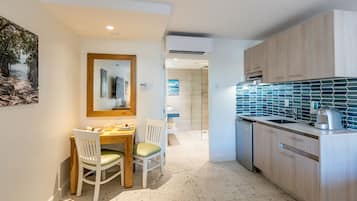 Una cocina moderna con armarios de madera, salpicadero de azulejos y un comedor con mesa y sillas.