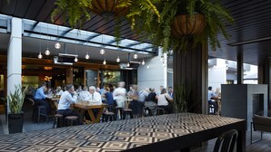 An outdoor dining area with hanging lights and potted plants. - Brassey Hotel (Barton)