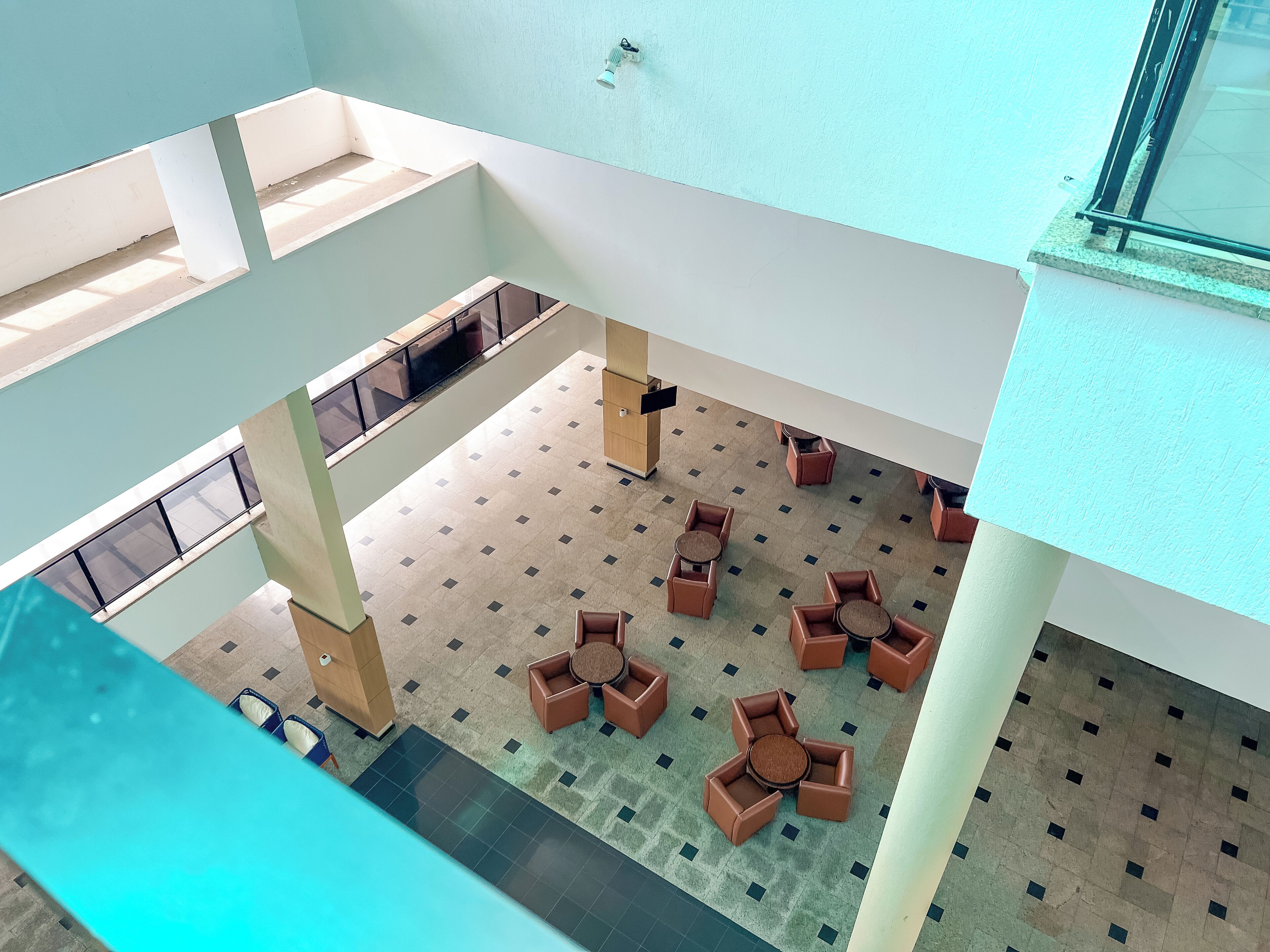 A spacious indoor area with multiple seating arrangements and a tiled floor.