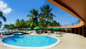 A pool area with a circular pool, white lounge chairs, and green umbrellas. - Marina Park (Fortaleza)
