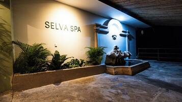 A spa entrance with a sign reading 'SELVA SPA' and a stone sculpture.
