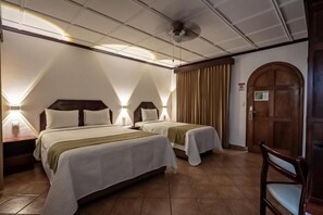 Ett hotellrum med två sängar, en trädörr och en stol.
