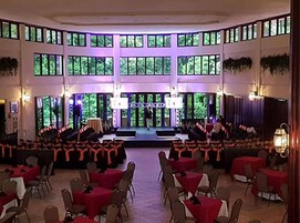 Un gran salón con asientos escalonados, un escenario y ventanas amplias.