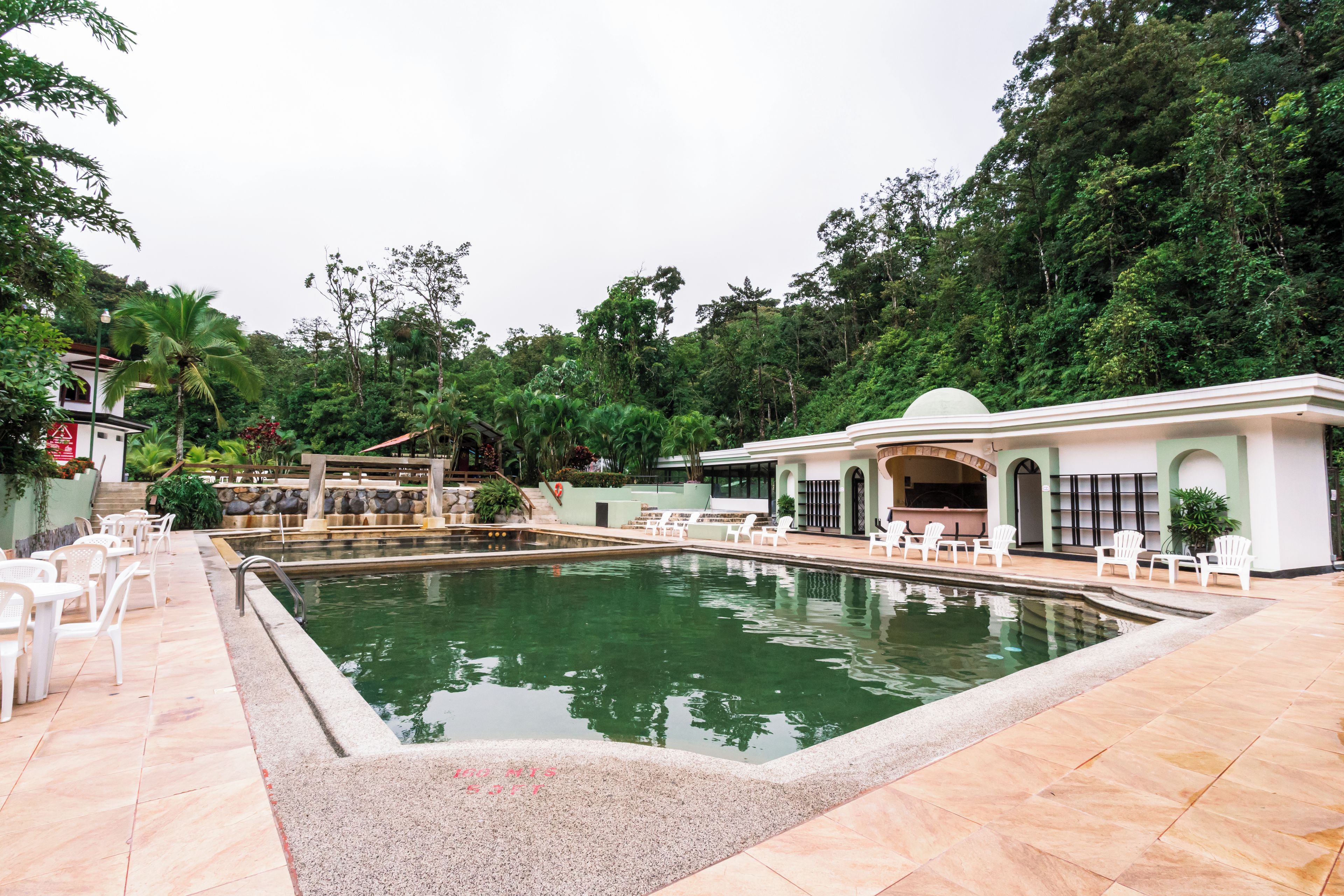 A swimming pool with lounge chairs and a building with a dome roof.