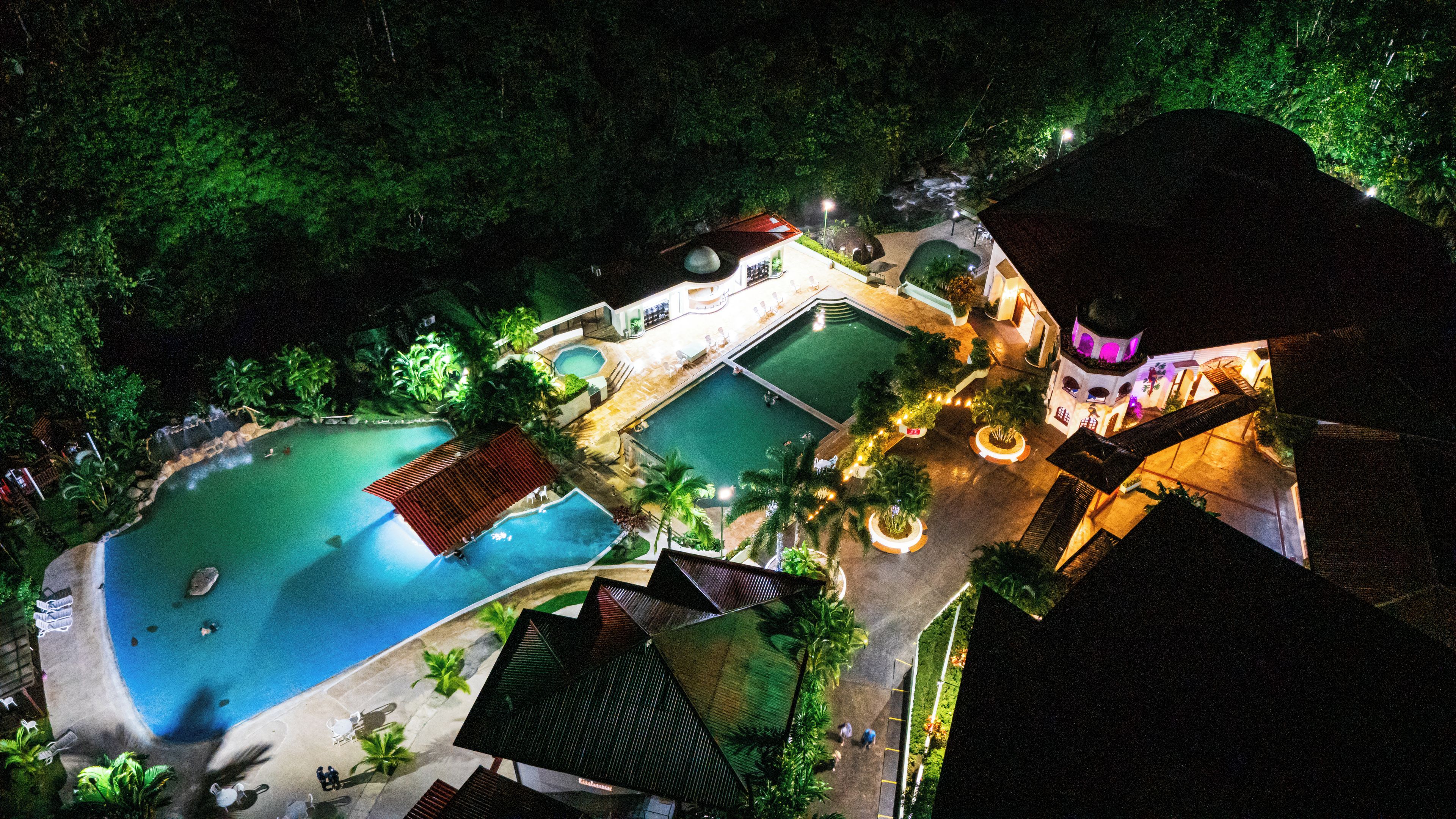 Resort com várias piscinas, área coberta e um edifício com cúpula.