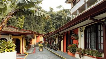 Un edificio con techo rojo, varias ventanas y una escalera que lleva a la entrada.