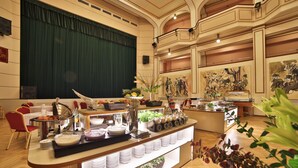 A buffet setup with various food items and a stage in the background. - Hotel Ariston & Ariston Patio (Prague)