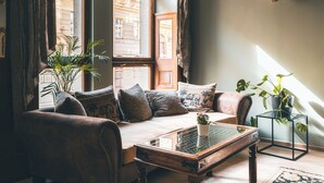 A cozy living room with a sofa, coffee table, and potted plants. - Hotel Ariston & Ariston Patio (Prague)