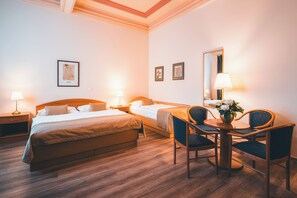 Driepersoonskamer | Een minibar, een kluis op de kamer, individueel gedecoreerd, een bureau