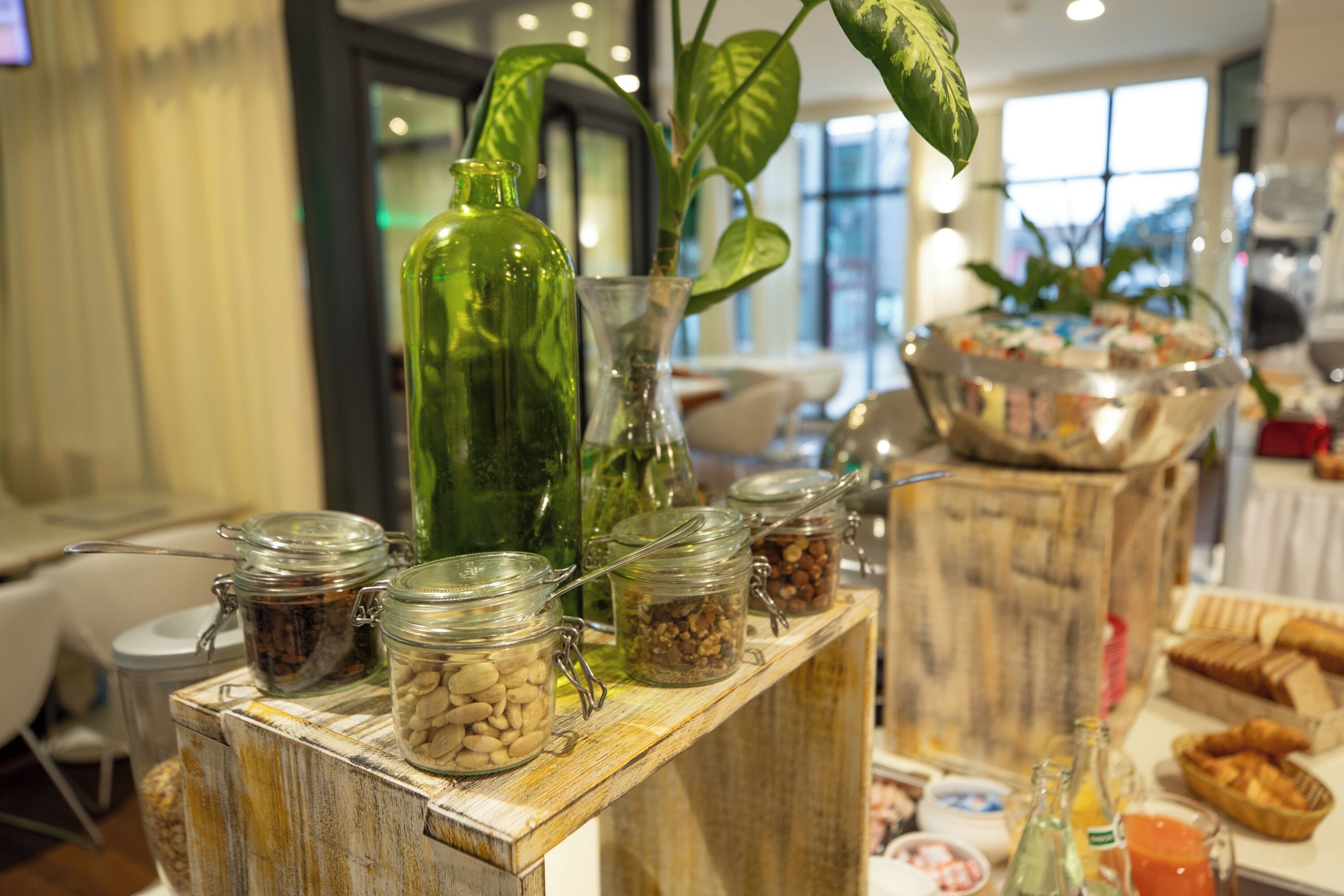 Un buffet proposant une variété de plats et d’assaisonnements présentés dans des bocaux en verre, le tout disposé sur une table en bois.