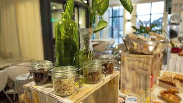 Una mesa de madera con un buffet variado, incluyendo alimentos y condimentos en frascos de vidrio.