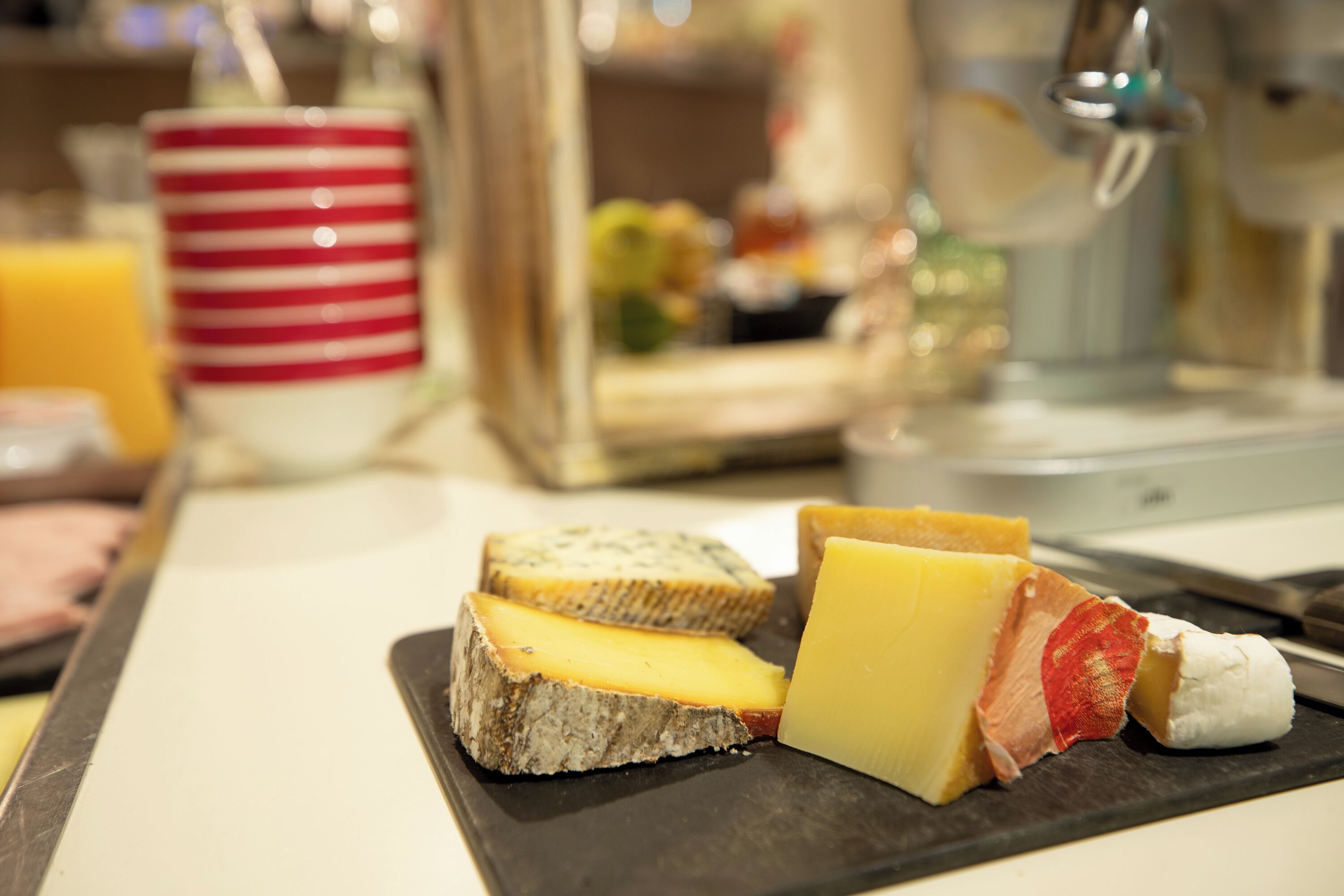 A selection of cheeses and bread on a slate board.