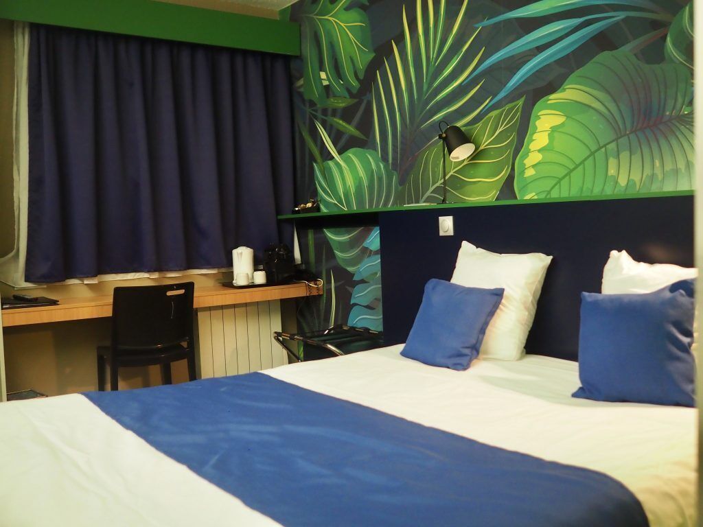 Una habitación de hotel con una cama, un escritorio y una silla.