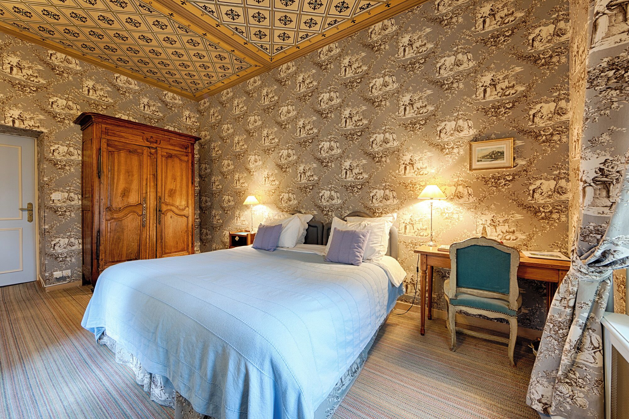 Une chambre à coucher avec un grand lit, une armoire en bois et un papier peint à motifs.