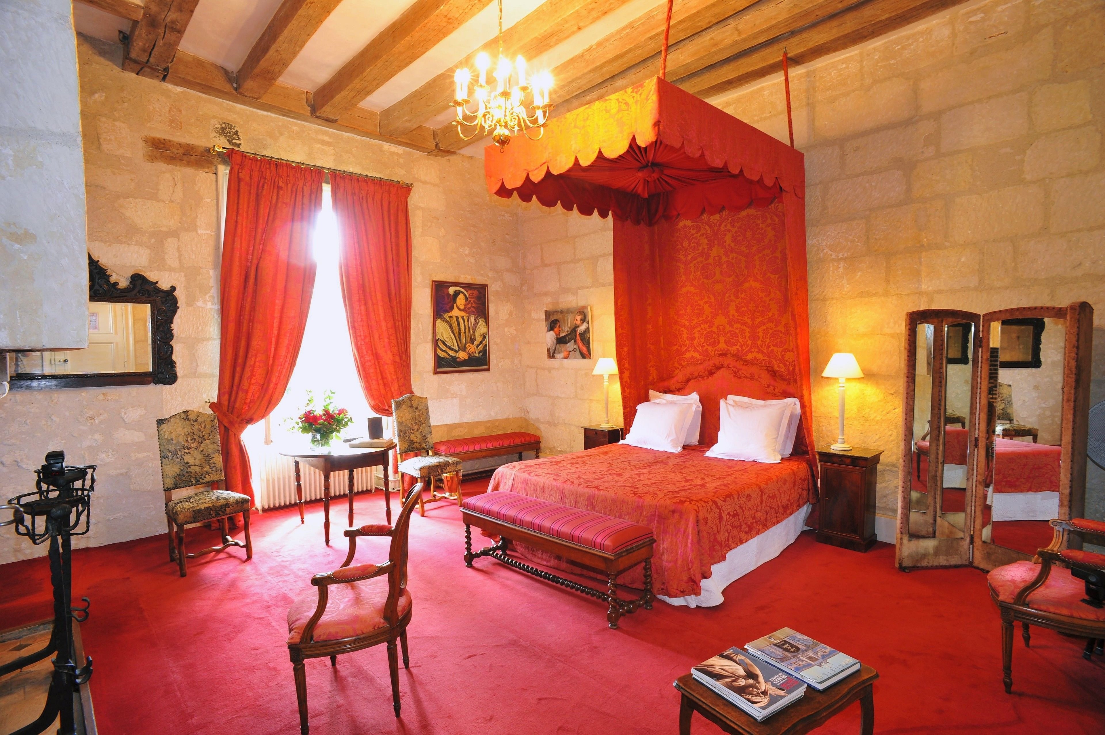 Une chambre traditionnelle avec un grand lit, des meubles en bois et un mur en pierre.
