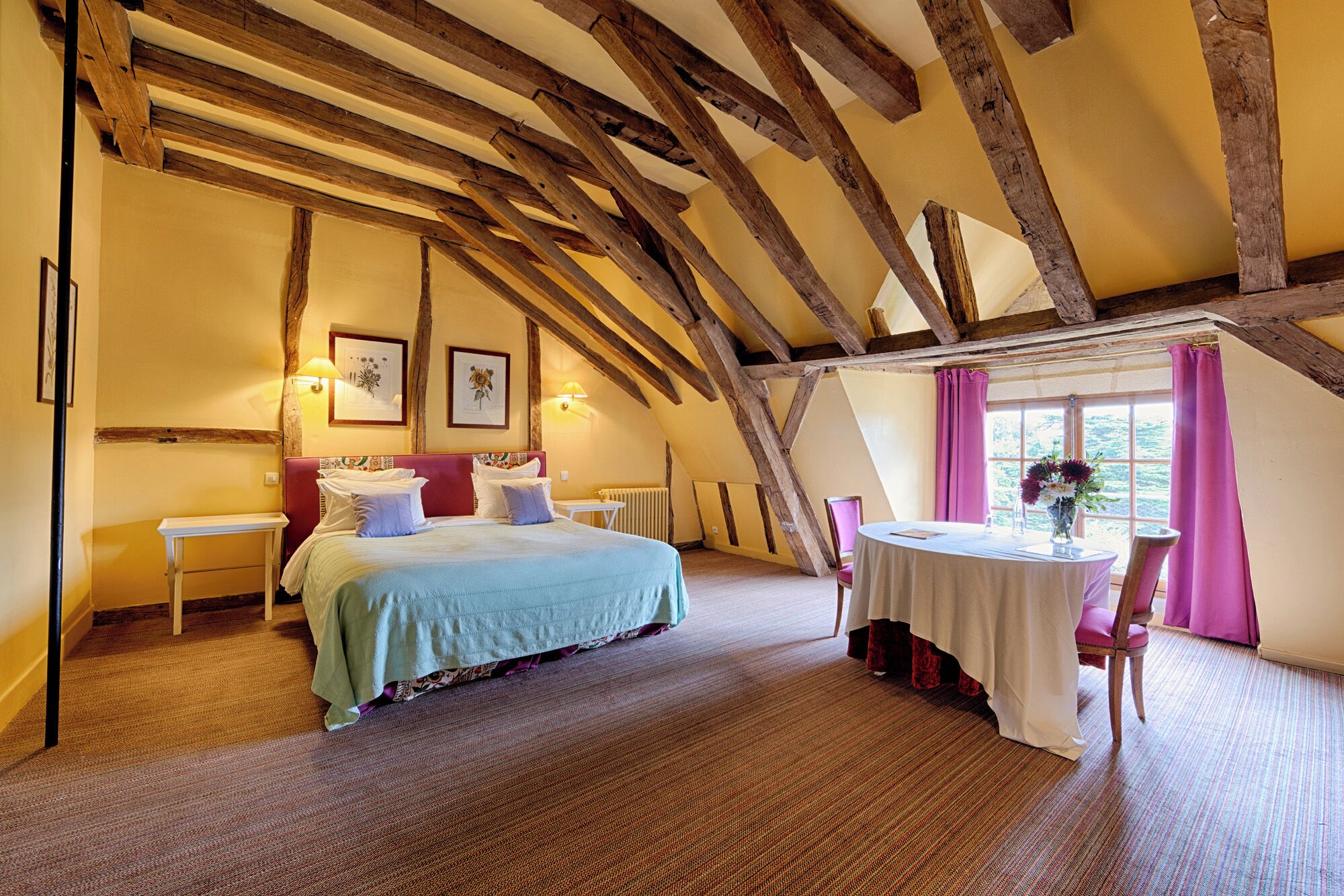 Ein Schlafzimmer mit einem Bett, einem Tisch mit Stühlen und einem Fenster mit Vorhängen.