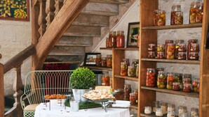 Una mesa con alimentos y frascos de conservas.