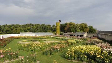 A garden with various flower beds and a tall tower structure.