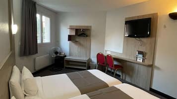 A hotel room with two beds, a desk, a chair, a TV, and a window with curtains.