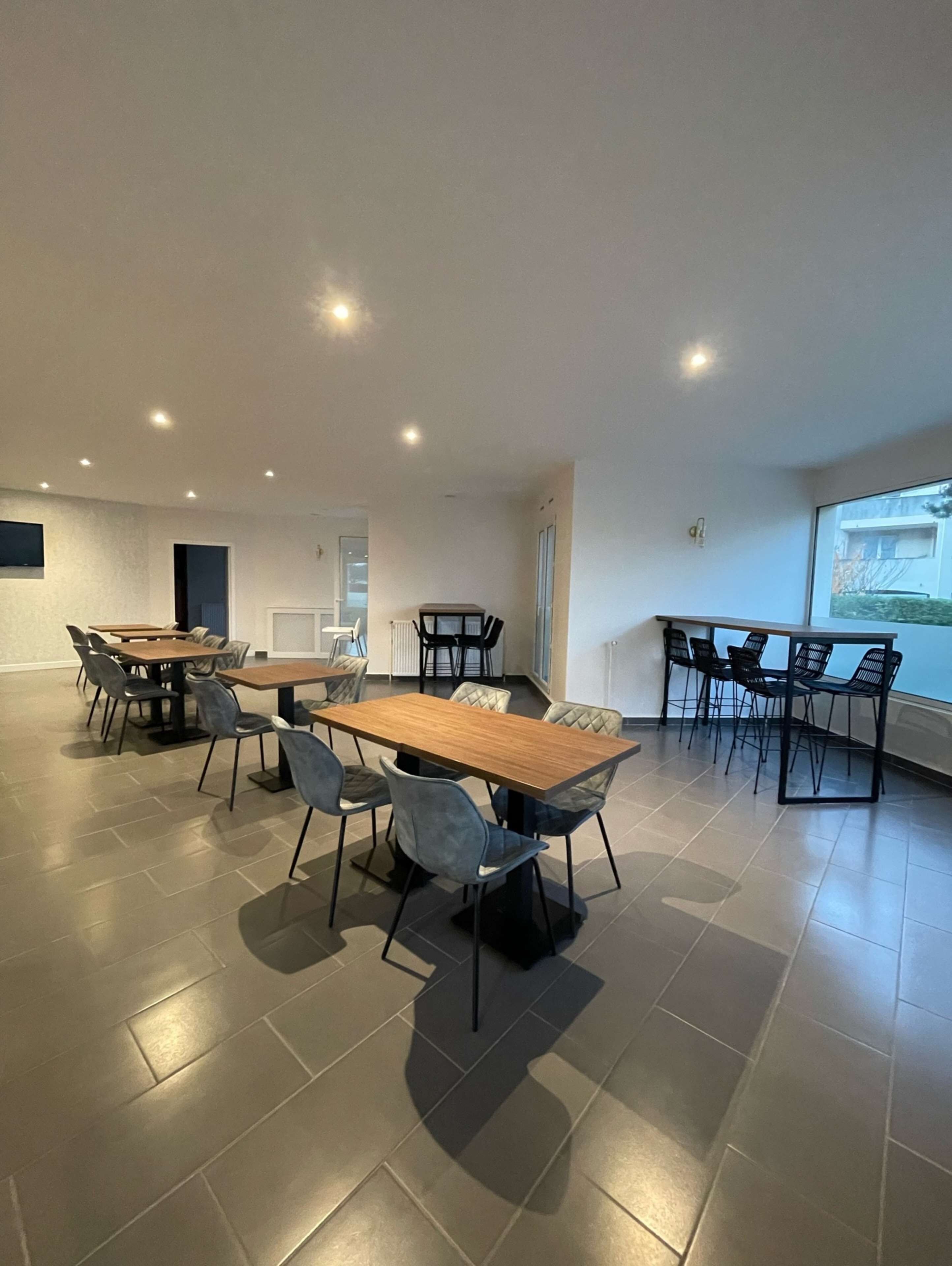 Una habitación amplia con una gran mesa de comedor y sillas, vistas al exterior y una decoración interior moderna.