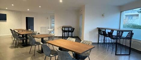 Una habitación amplia con una gran mesa de comedor y sillas, vistas al exterior y una decoración interior moderna.