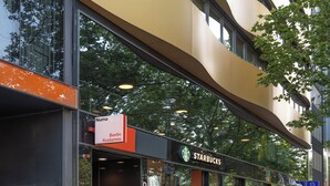 A modern building with a curved facade, a Starbucks coffee shop, and a sign for 'Numa Berlin Kudamm'. - Numa Berlin Kudamm (Berlin)