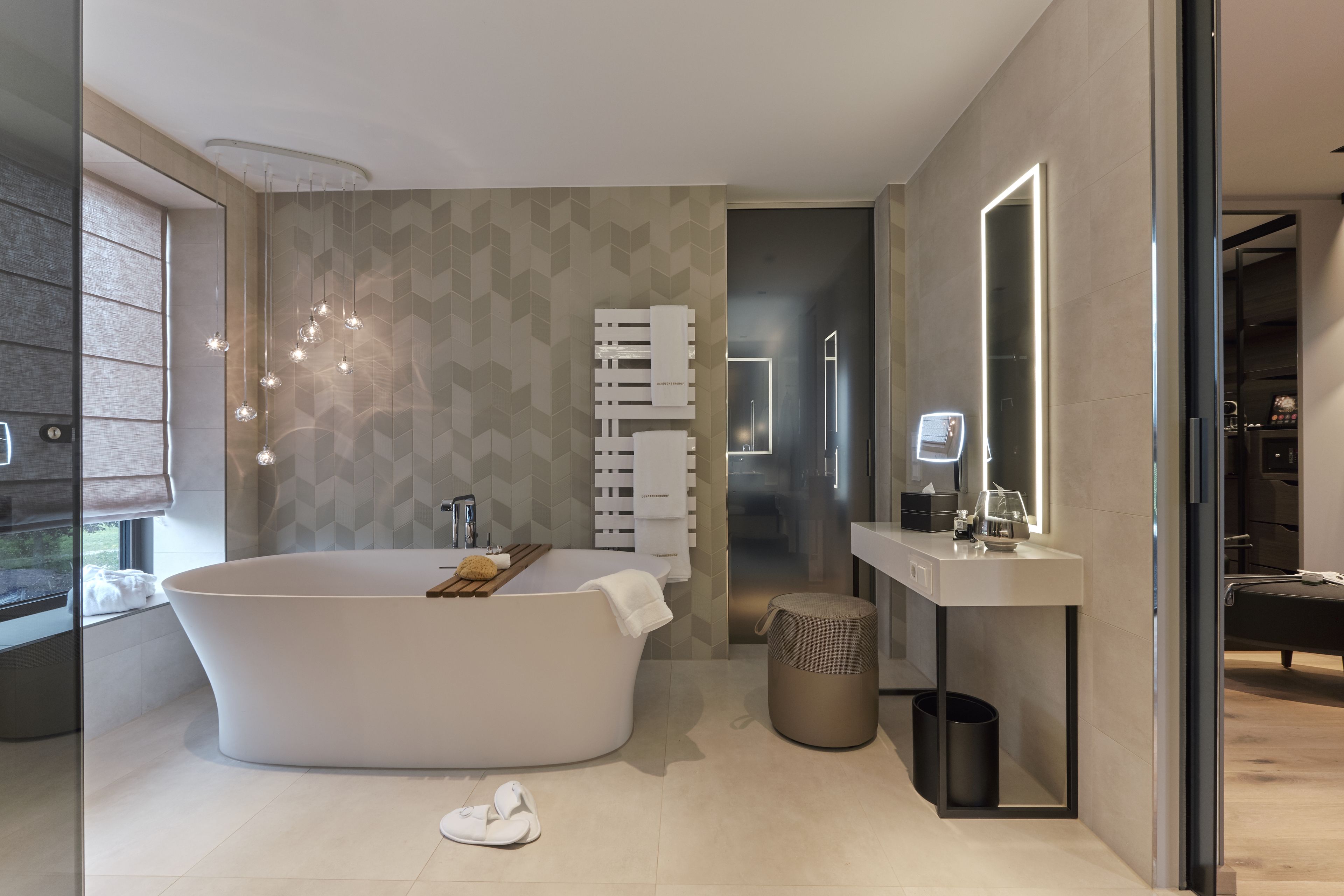 A modern bathroom with a freestanding bathtub, a vanity with a mirror, and a shower area.