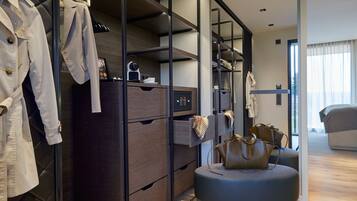 Une chambre d’hôtel moderne dotée d’un dressing, d’un pouf rond et d’un grand lit.