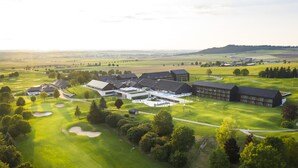 A golf course with multiple buildings, including a clubhouse and residential structures. - Severin*s Resort & Spa Öschberghof (Donaueschingen)