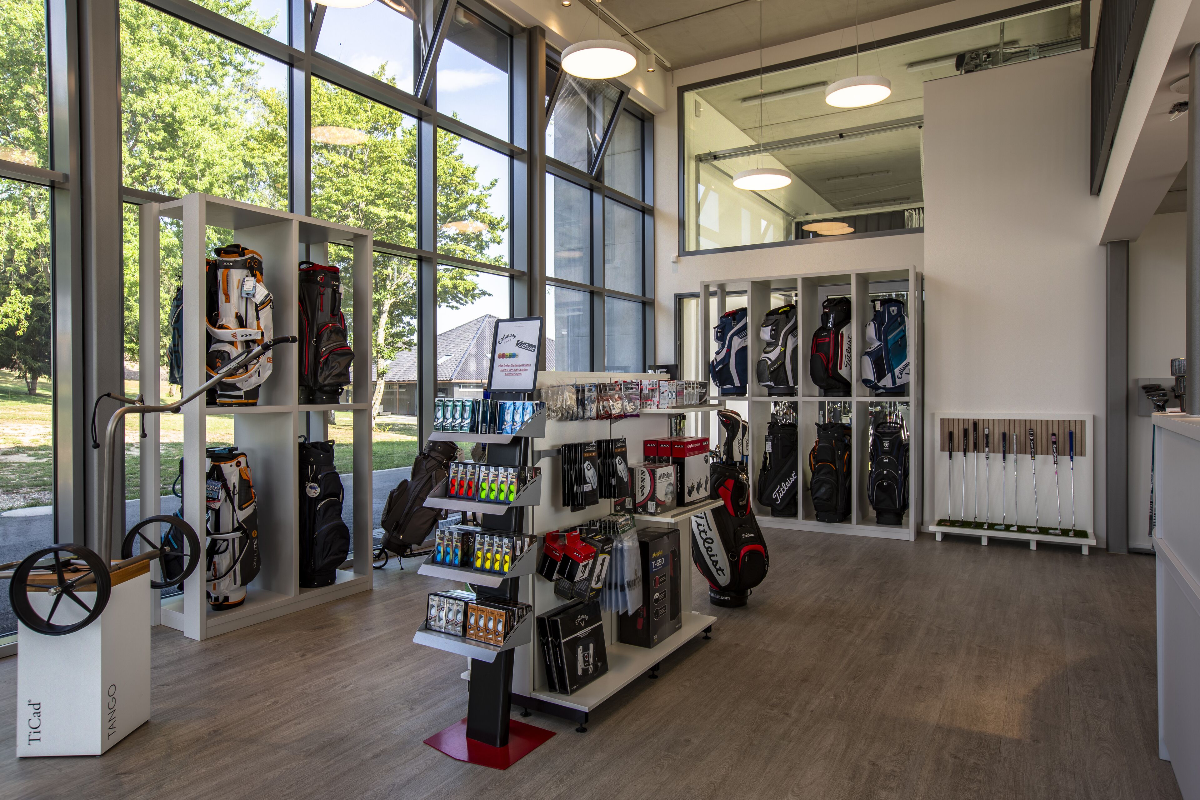A golf equipment store with shelves of golf bags, clubs, and accessories.