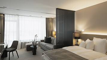 Una habitación de hotel con cama, sofá, escritorio y una silla.