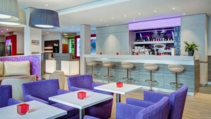 Un área de bar moderna con asientos y una barra.