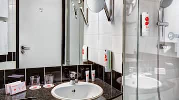 Une salle de bain moderne avec un lavabo, un miroir et une douche à parois de verre.