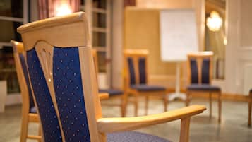 A wooden chair with a blue cushioned backrest and a wooden armrest.
