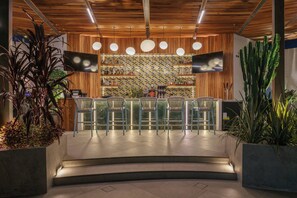 Un área de bar moderna con techo de madera, taburetes y pared con diseño.