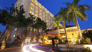 A hotel with a modern facade, a well-lit entrance, and a palm tree in the foreground. - InterContinental Real San Pedro Sula by IHG (San Pedro Sula)