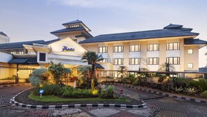 A hotel with a traditional architectural style, featuring a prominent sign and a landscaped entrance area. - Prime Plaza Hotel - Purwakarta (Cikampek)
