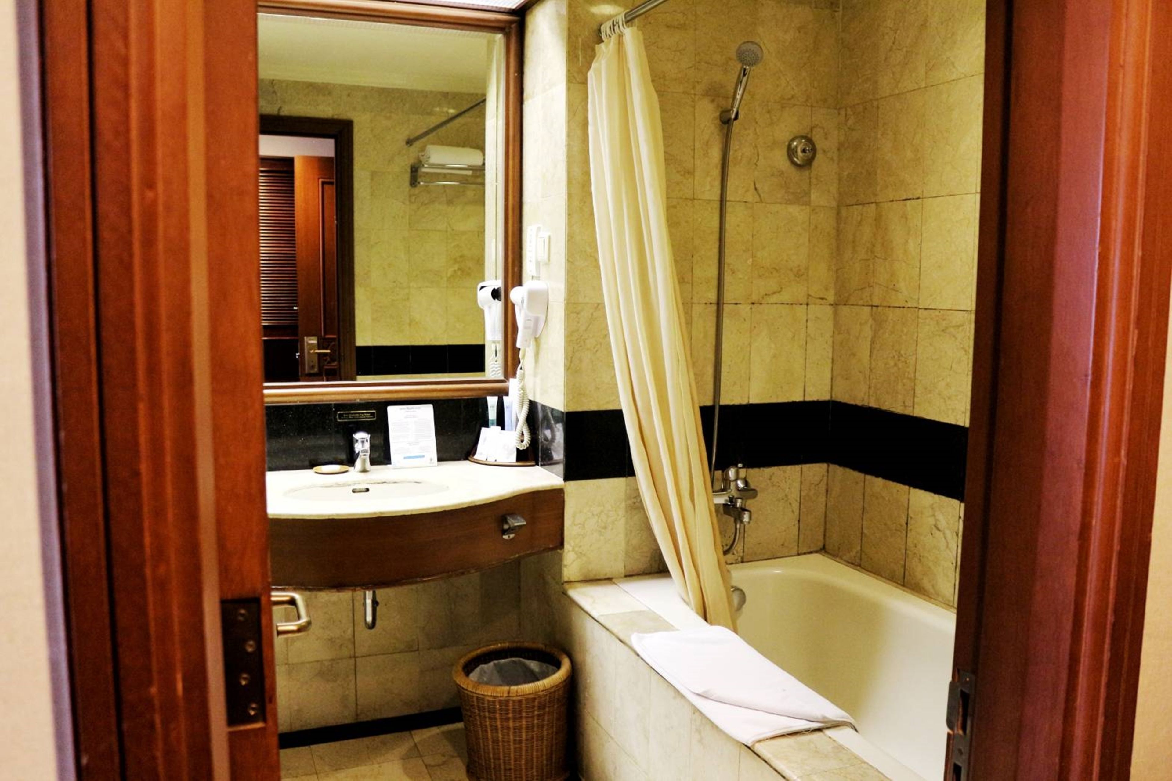 Une salle de bain avec une baignoire, une douche, un lavabo et un miroir.