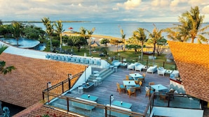 Terraza en la azotea con mobiliario exterior, piscina y vistas a la playa y al océano.