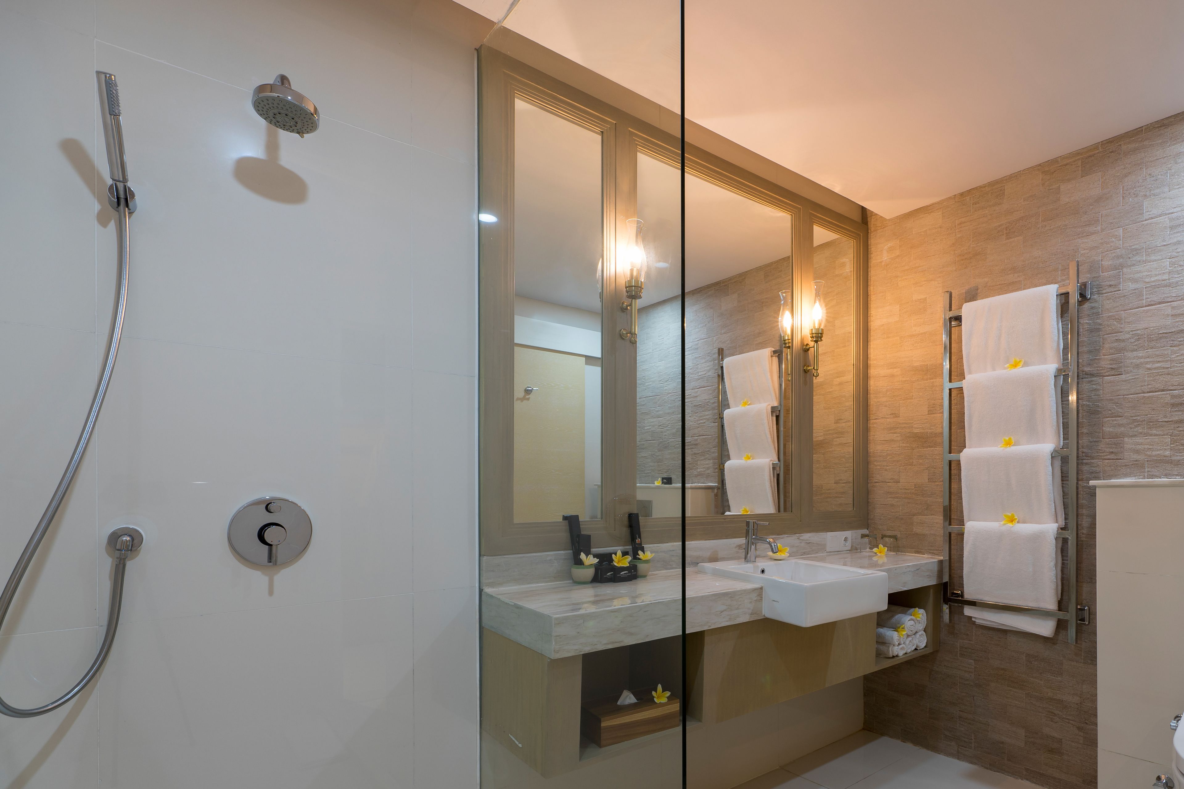 A modern bathroom with a glass shower enclosure, a double sink vanity, and a towel rack.