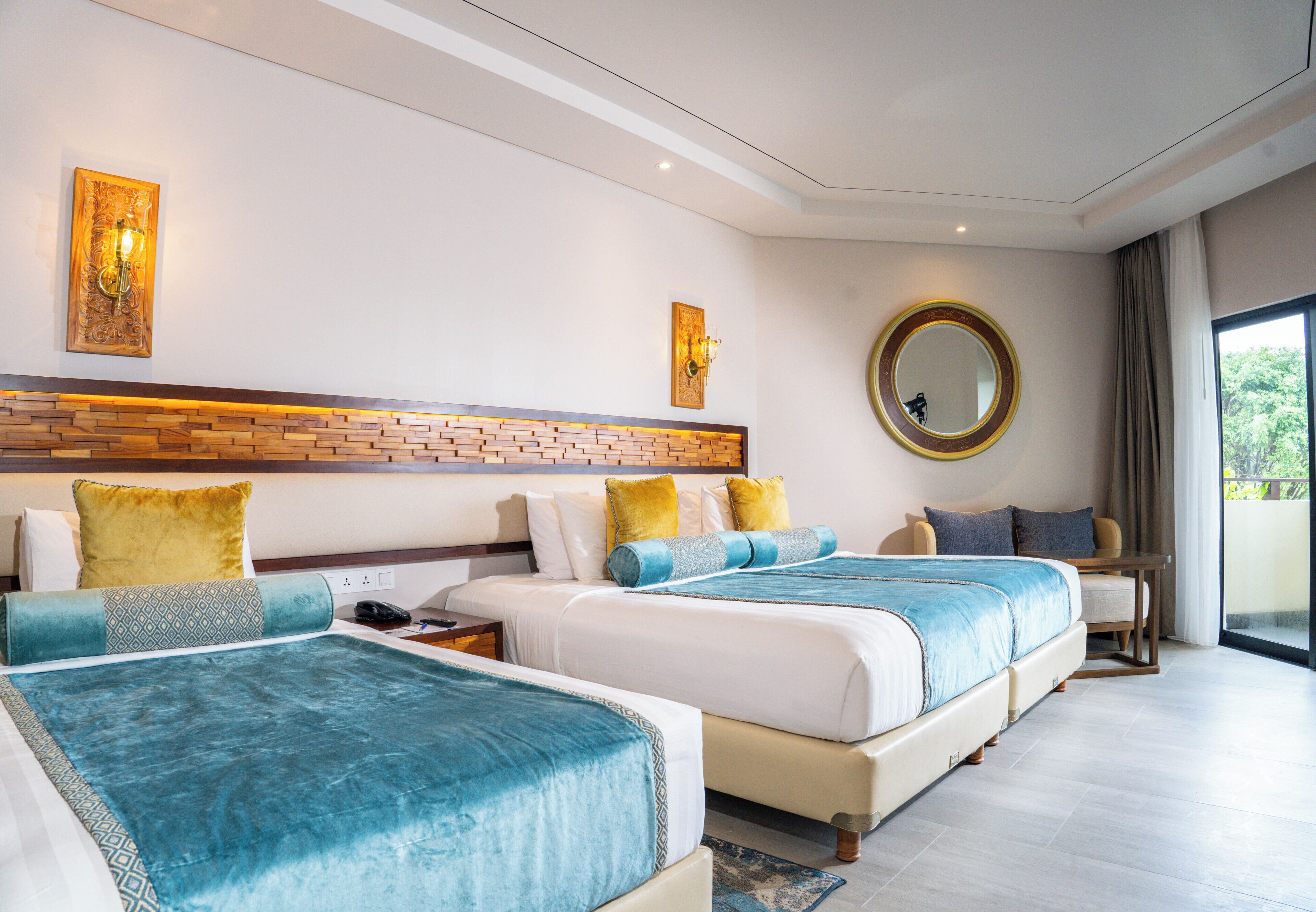 Ein Hotelzimmer mit zwei Betten, einem großen Spiegel und Blick ins Freie.