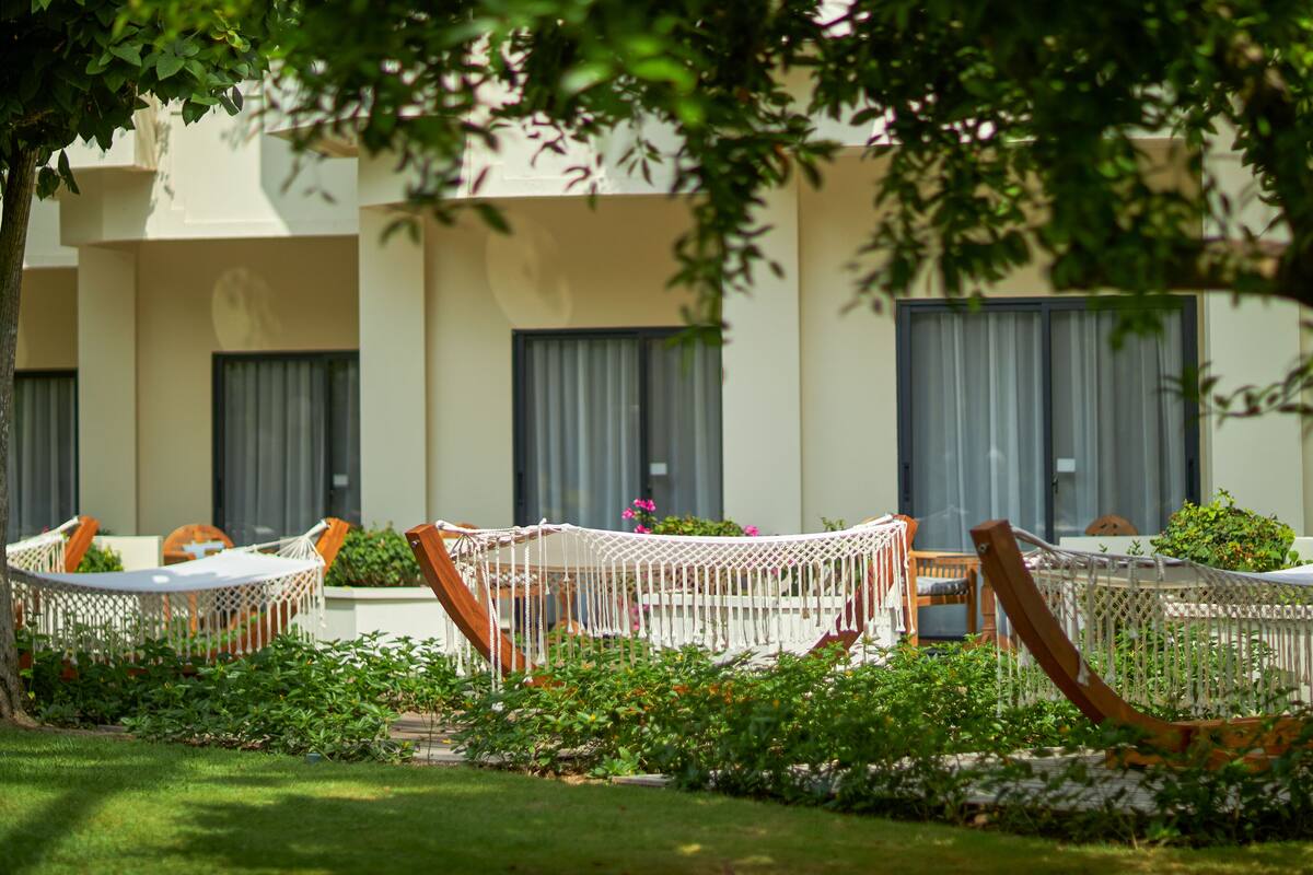 Un jardin avec un espace aménagé pour s’asseoir à l’extérieur et un bâtiment en arrière-plan.