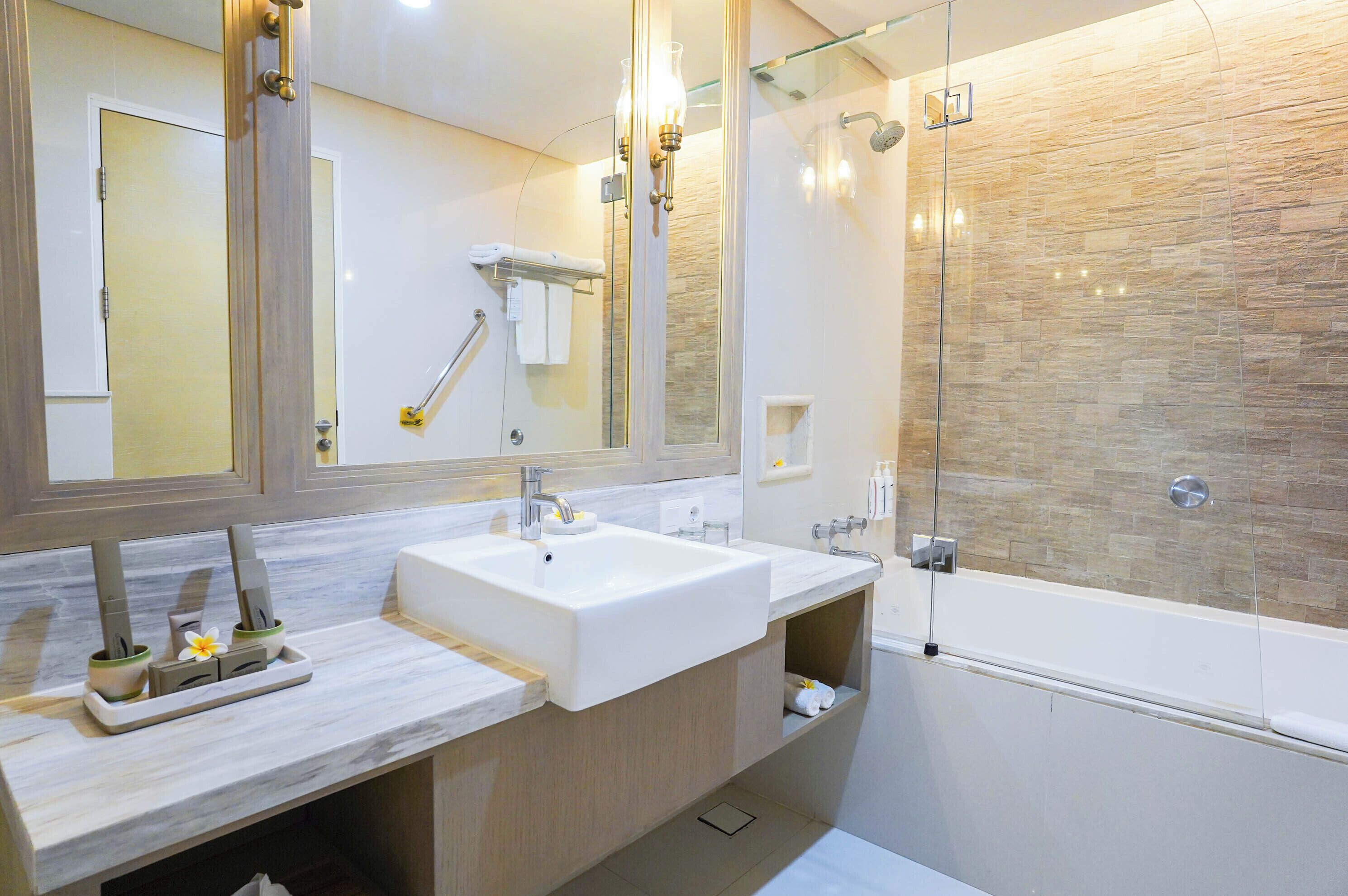 Un baño moderno con dos lavamanos, cabina de ducha de vidrio y un espejo grande.