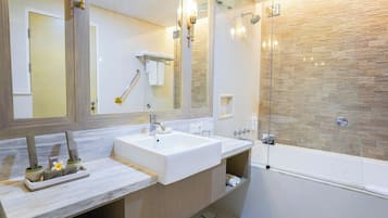 Un baño moderno con dos lavamanos, cabina de ducha de vidrio y un espejo grande.