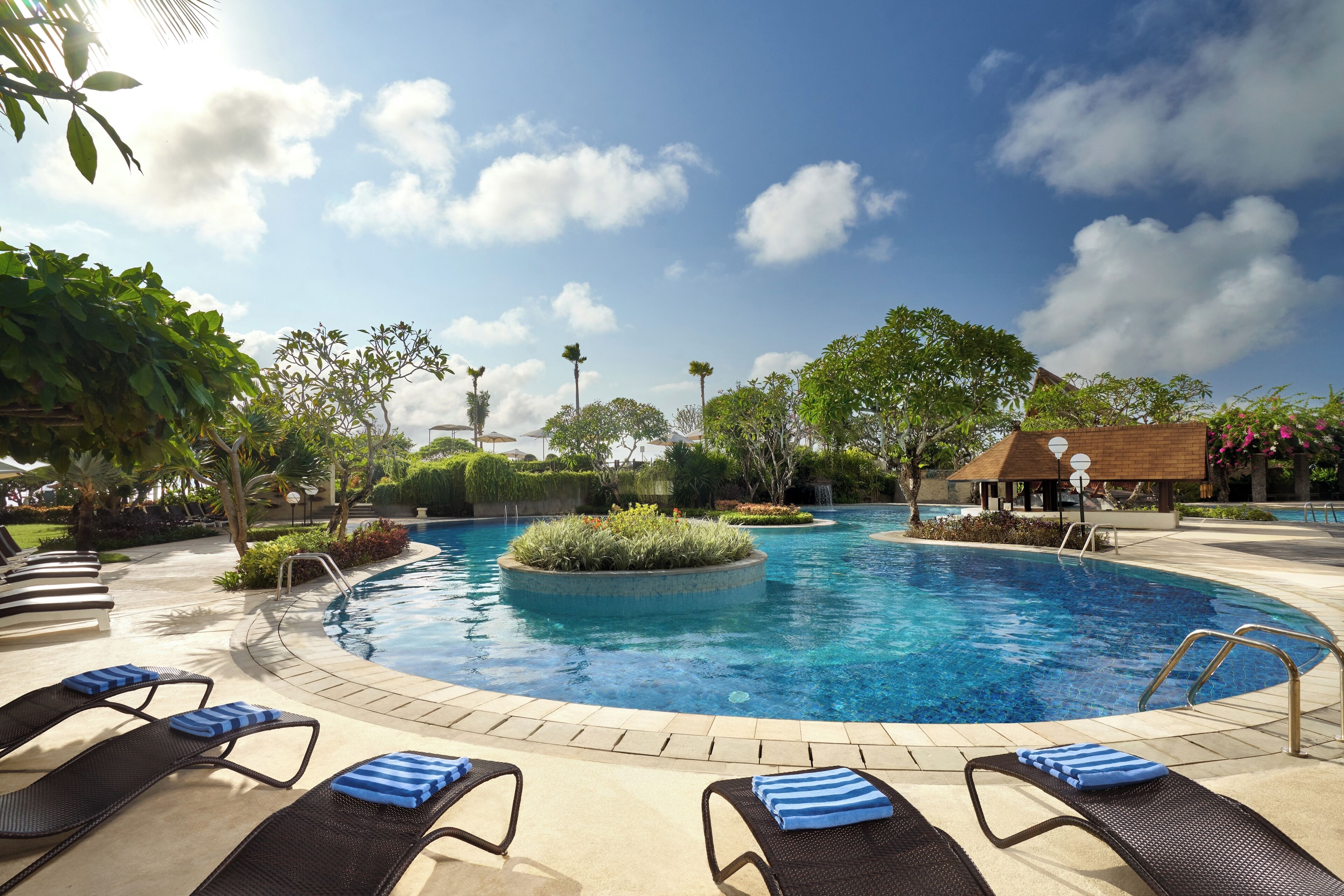 A swimming pool with lounge chairs and a small gazebo.