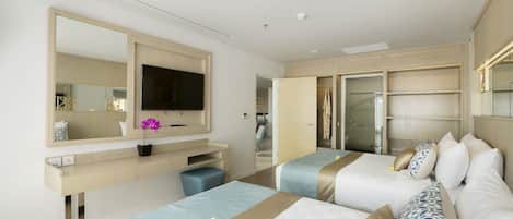 Habitación de hotel con dos camas, televisión, espejo y baño con ducha.